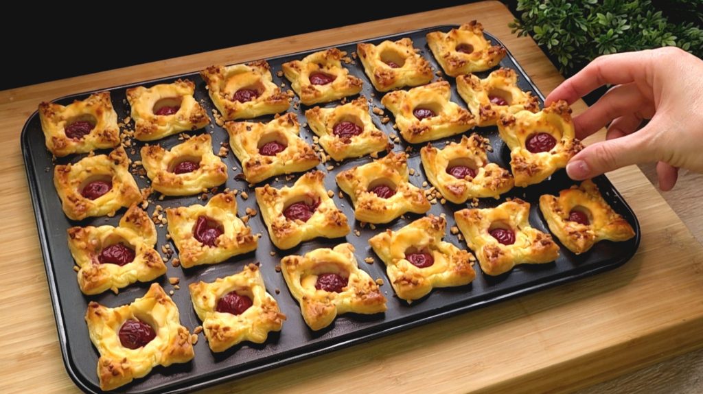 Goldbraun gebackene Mini-Muffins aus Blätterteig gefüllt mit Vanillequark, einer Sauerkirsche und gehackten Haselnüssen.