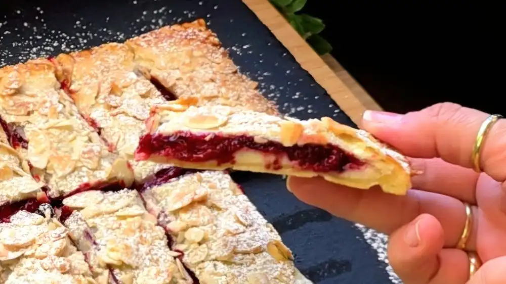 Detailansicht eines aufgeschnittenen Blätterteig-Riegels mit fruchtiger Beerenfüllung und samtiger Vanille-Quarkcreme.