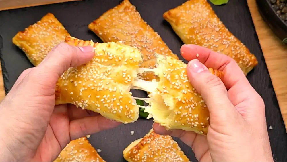 Detailansicht einer aufgeschnittenen Tasche zeigt die saftige Hähnchenbrust, geschmolzenen Käse und Tomaten.