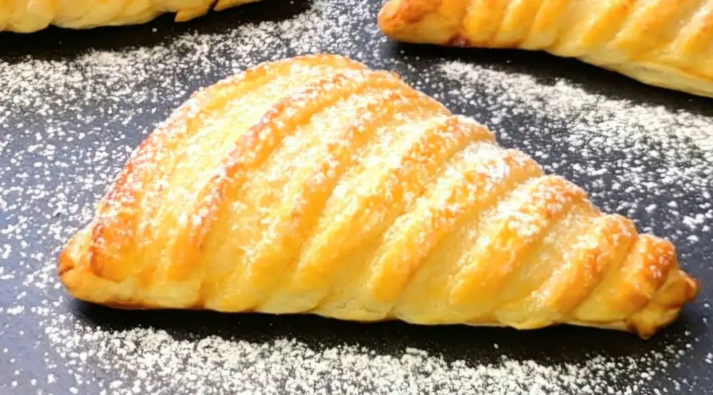 Detailansicht einer gebackenen Quarktasche zeigt die cremige Füllung und die heißen Erdbeeren.