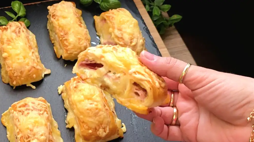 Detailansicht einer frisch gebackenen Blätterteig-Tasche mit geschmolzenem Käse und feinem Prosciutto.