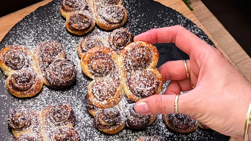 Detailansicht eines Schoko-Blätterteig-Schmetterlings, bei dem die krossen, blättrigen Teigschichten und die dunkle Nuss-Nougat-Creme perfekt zu sehen sind.