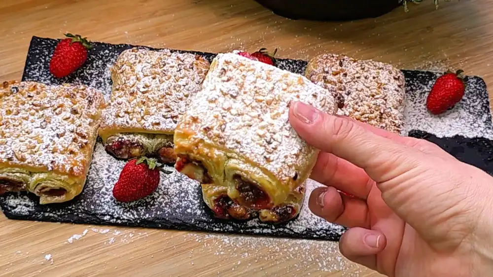 Detailansicht eines aufgeschnittenen Erdbeer-Schoko-Kissens mit geschmolzenem Schokoladenkern.