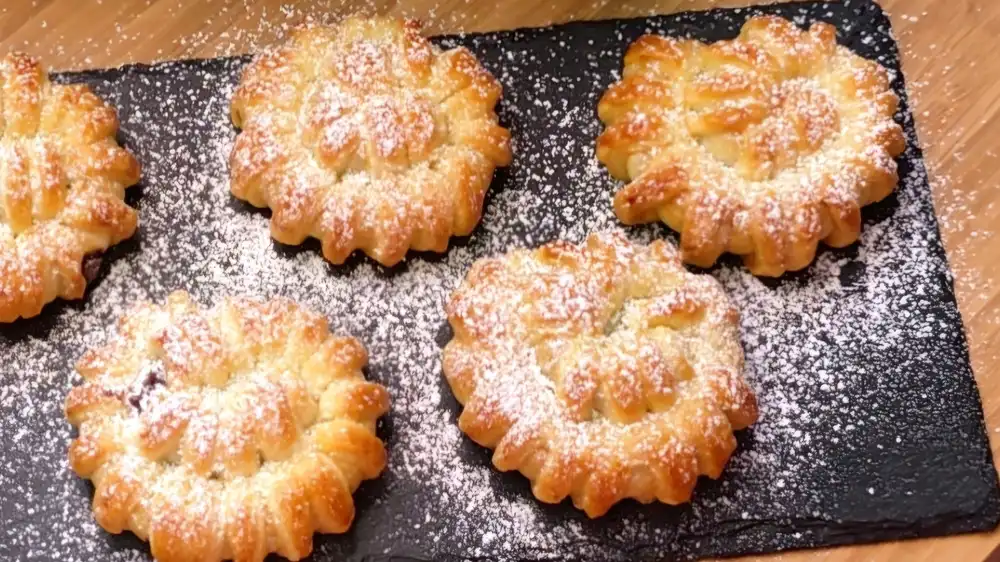 Detailansicht eines frisch gebackenen Schoko-Kipferls mit feinem Streifenmuster und flüssigem Nutellakern.