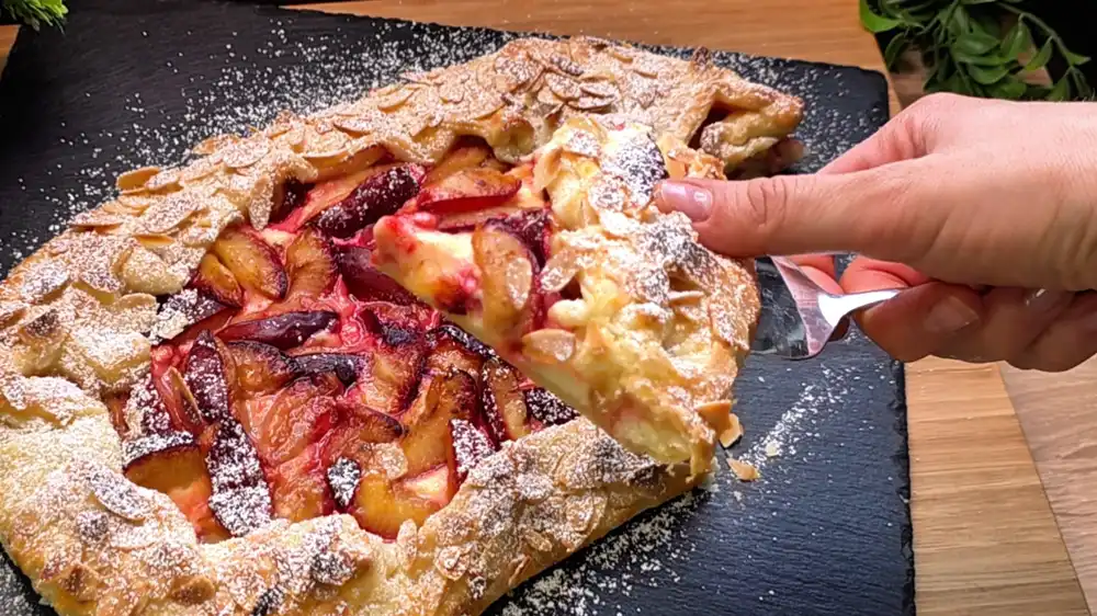 Detailansicht der Galette mit Fokus auf die saftigen, mit Zimt-Zucker bestreuten Zwetschgenspalten auf der cremigen Quark-Schicht.
