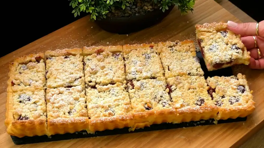 Goldbraun gebackener Blätterteig-Quark-Kirsch-Kuchen mit dicker Streuselschicht und Puderzucker.
