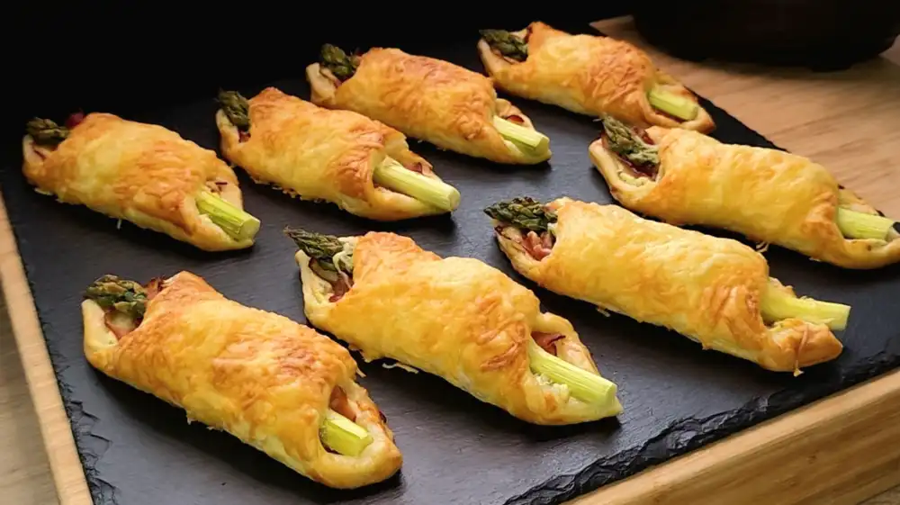 Goldbraun gebackene Blätterteig-Schinken-Spargel-Taschen mit geschmolzenem Käse.