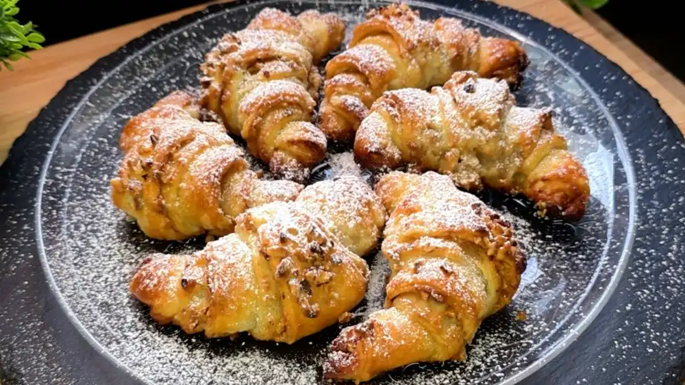 Goldbraun gebackene Blätterteig-Croissants mit Zimt-Butter-Füllung und gehackten Haselnüssen.