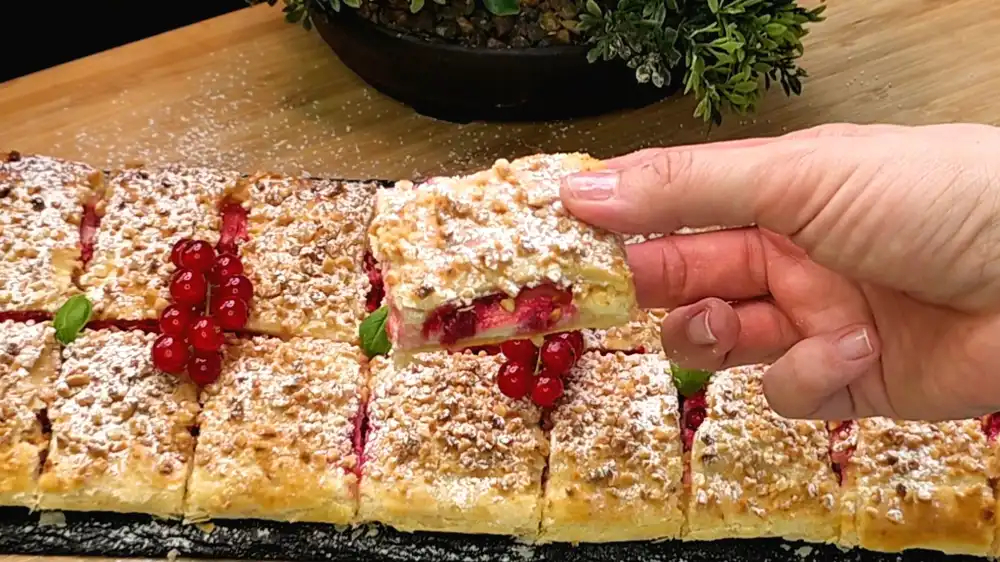 Detailansicht einer aufgeschnittenen Quarktasche aus Blätterteig mit Fokus auf die cremige Vanille-Quarkfüllung und die leuchtend roten Beeren.