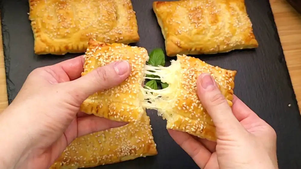 Detailansicht einer aufgeschnittenen Schinken-Käse-Tasche mit gekochtem Ei und geschmolzenem Käse.