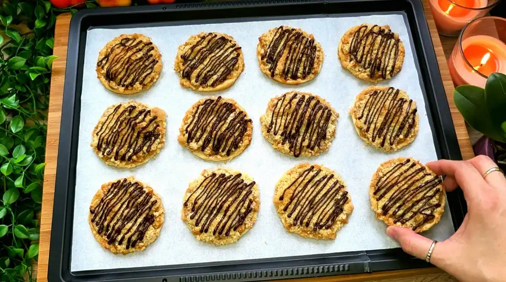 Goldbraun gebackene Apfel-Mini-Streuselkuchen aus Blätterteig mit geschmolzener Schokolade.