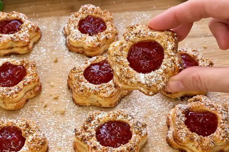 Nahaufnahme einer Blätterteig-Blume mit Erdbeerkonfitüre