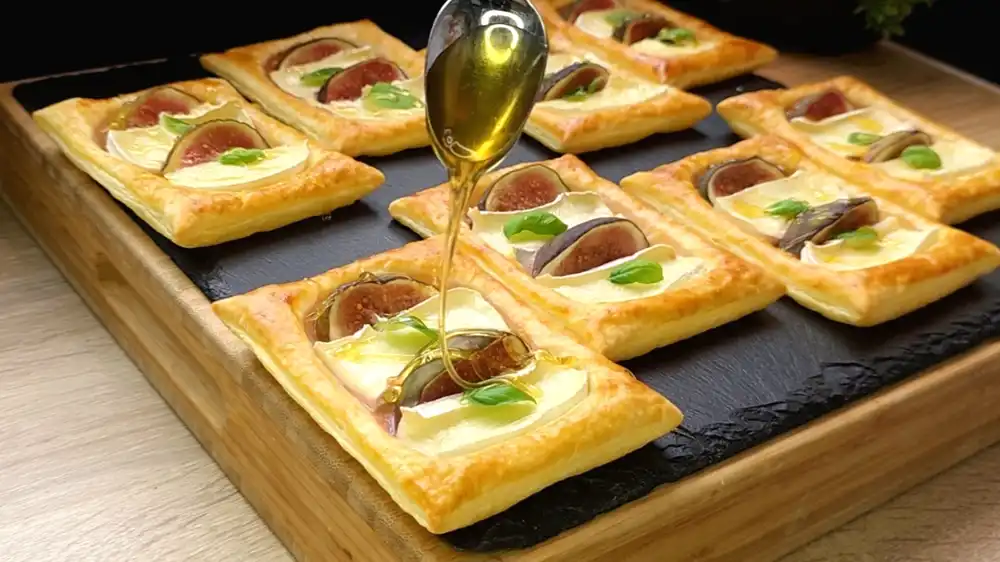 Goldbraun gebackener Blätterteig belegt mit geschmolzenem Camembert, frischen Feigen und Honig.