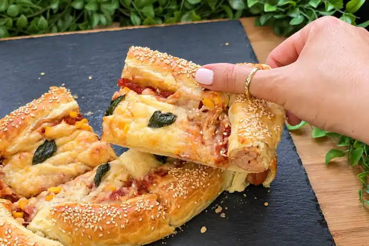 Nahaufnahme der Blätterteig-Pizza mit Würstchenrand
