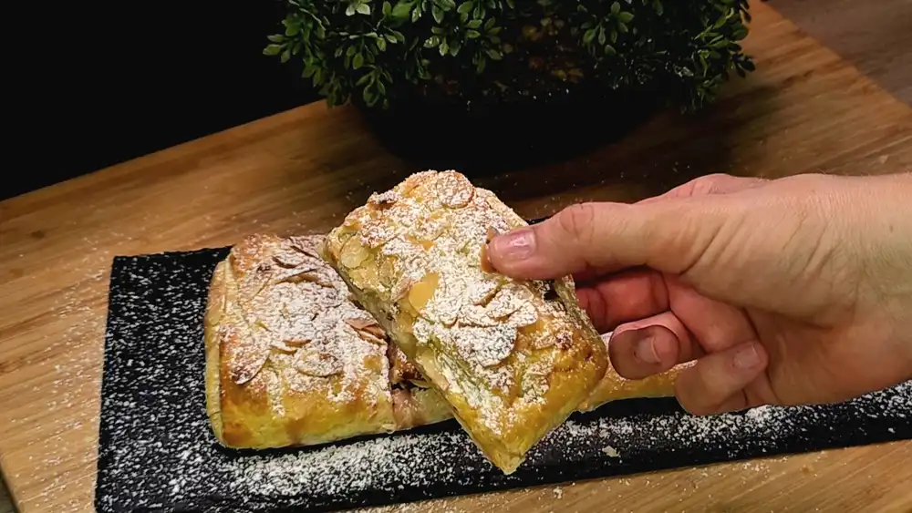 Detailansicht des geflochtenen Blätterteigstrudels mit herausspitzenden Feigenspalten und cremiger Quarkfüllung.