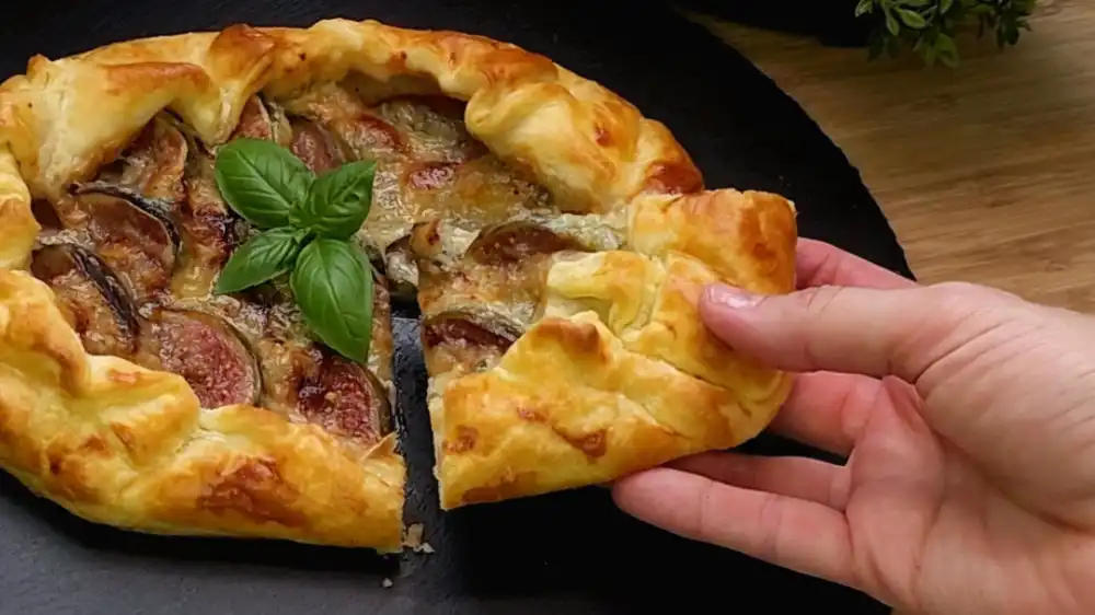 Detailansicht einer gebackenen Blätterteig-Galette mit geschmolzenem Gorgonzola-Käse und weichen Feigen.