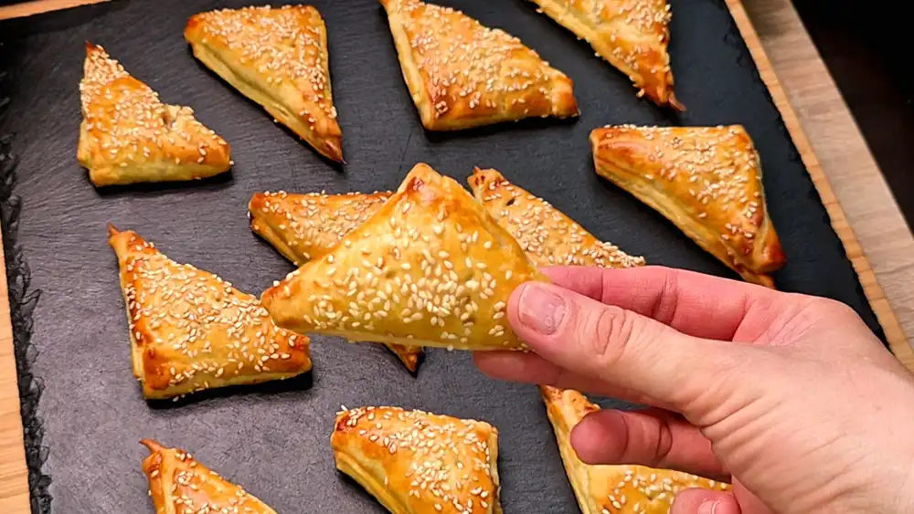 Nahaufnahme eines knusprigen Thunfisch-Dreiecks aus Blätterteig mit Sesam