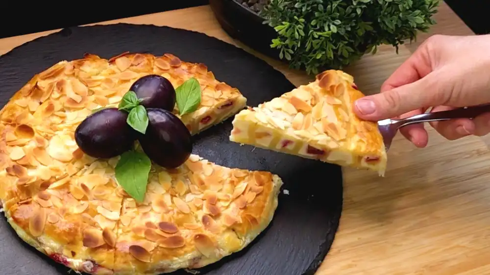 Nahaufnahme der Zwetschgen-Quark-Schnecke mit Mandeln