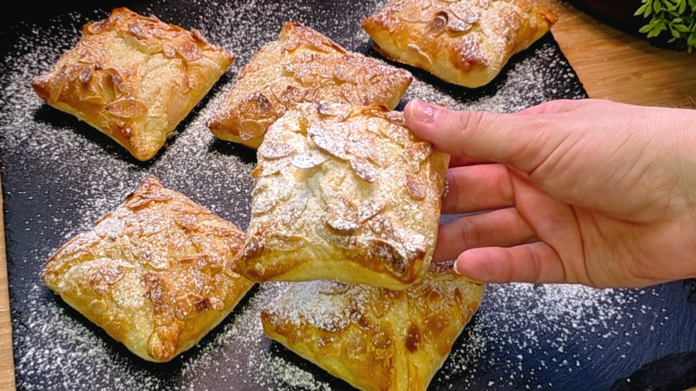 Nahaufnahme cremiger Apfel-Quark-Taschen aus Blätterteig mit Mandeln