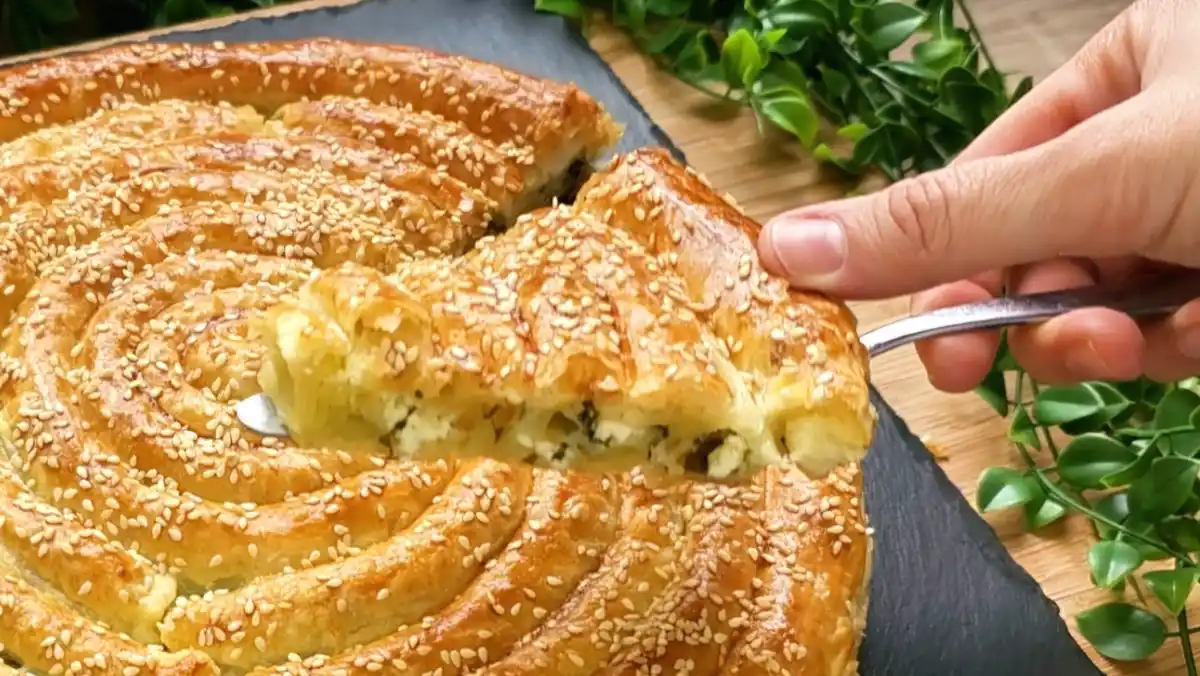 Nahaufnahme einer großen Börek-Schnecke aus Blätterteig mit Spinat und Feta
