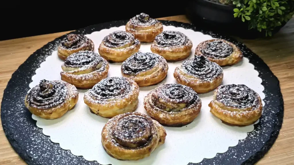 Kakao-Schnecken aus Blätterteig mit Butter und gezuckertem Kakaopulver
